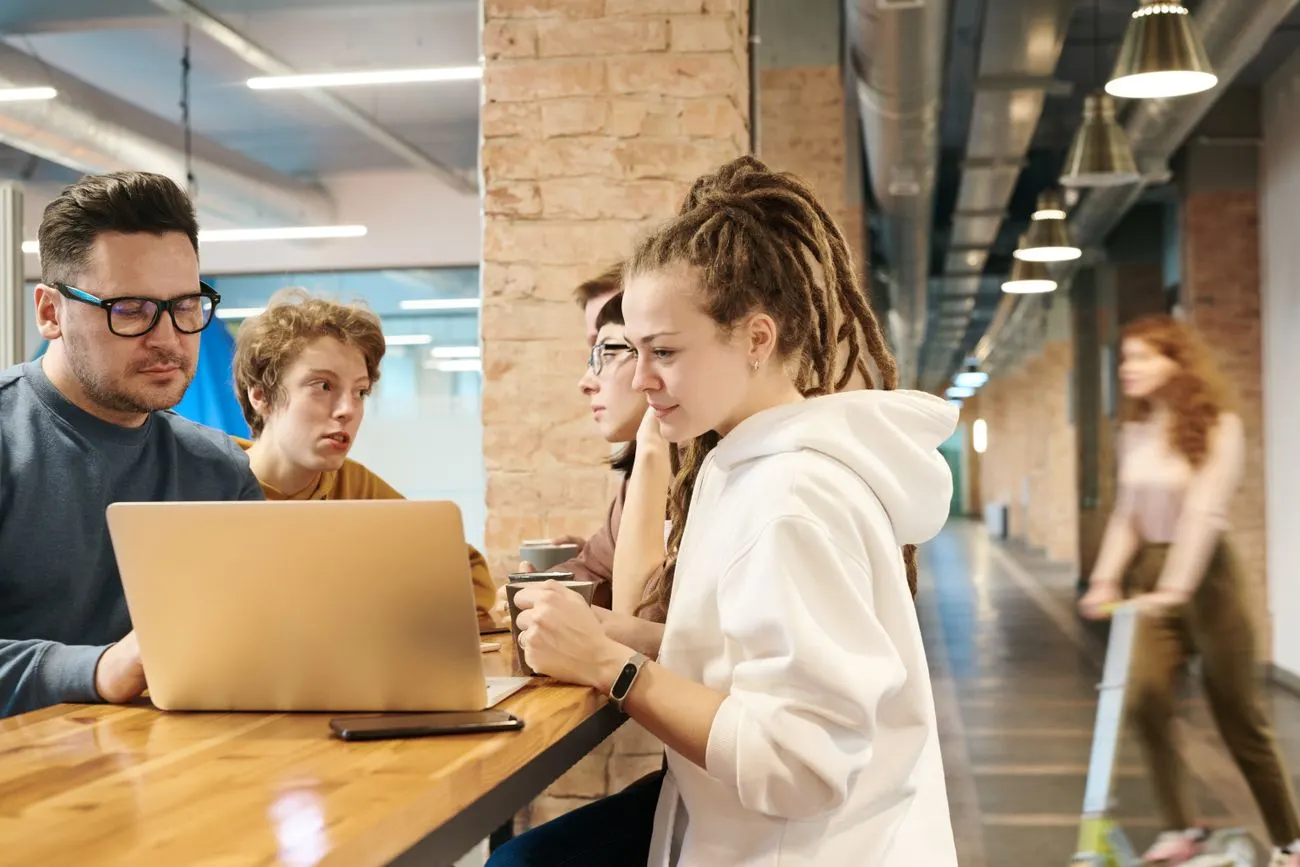 Personas colaborando con una computadora en un espacio de trabajo